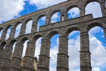 Aqueduct in Spain with the background of blue sky with a lot of clouds in summer, cultural and historical monument