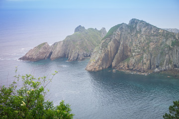 Amazing landscape with ocean, cliffs, beach, greens and flowers in summer day; wallpaper of the Bay of Biscay