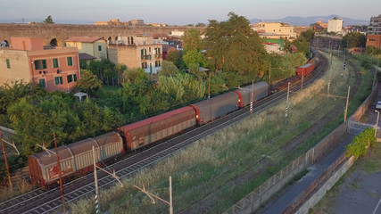 Fototapeta na wymiar Passaggio di un vecchio treno merci in un tratto isolato in curva della ferrovia italiana