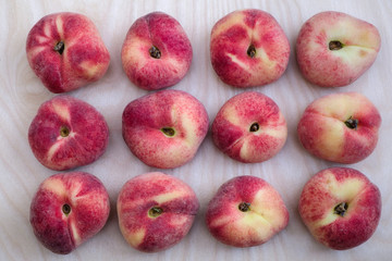 Flat lay of 12 fresh ripe saturn peach.