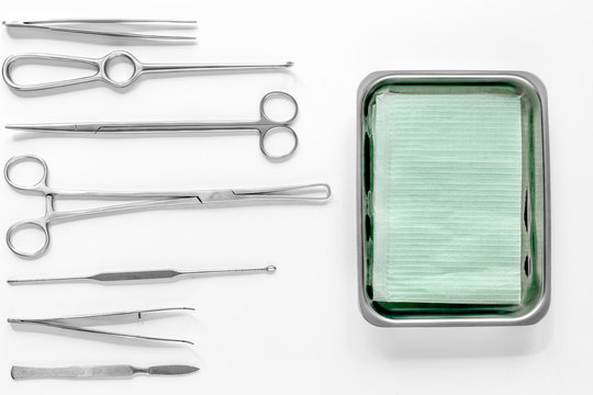 Surgical instruments and tools including scalpels, forceps and tweezers on white table top view mock upmock up