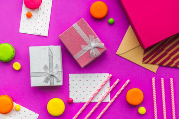 Birthday greeting cards and wrapped gifts on fuchsia background top view