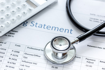health care billing statement with doctor's stethoscope on stone background