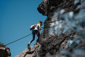 Junge Frau benutzt während einer Wanderung einen Klettersteig 