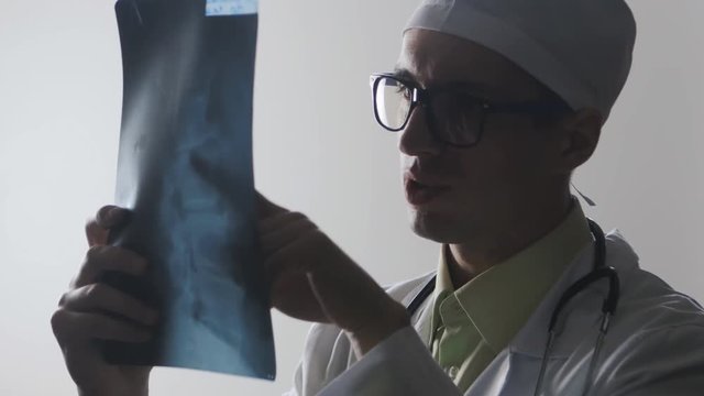 The doctor is studying an X-ray. Diagnosis of a disease