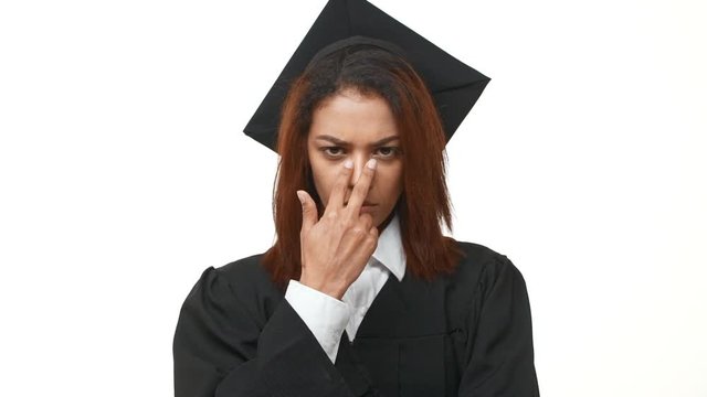 Strict frown African American female graduate pointing to look right into her eyes standing over white background in slowmotion