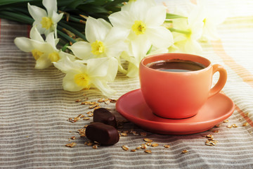 Cup of black coffee and daffodil flowers