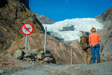 Unidentified couple enoying the view of the Franz Josef Glacier and valley floor, Westland, South...