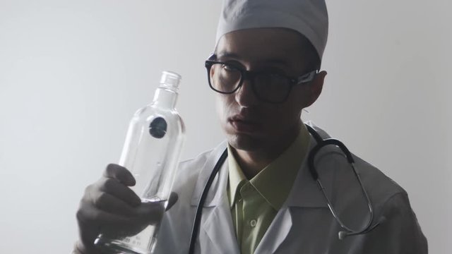 Portrait of Drunk doctor. A medical worker drinks vodka.
