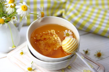 мед в сотах в керамической миске с ромашкой