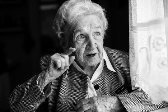 Portrait of an elderly women emotionally. Black-and-white photo.