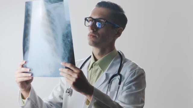 Portrait of a doctor at work. Doctor is studying an X-ray. A medical worker makes diagnosis