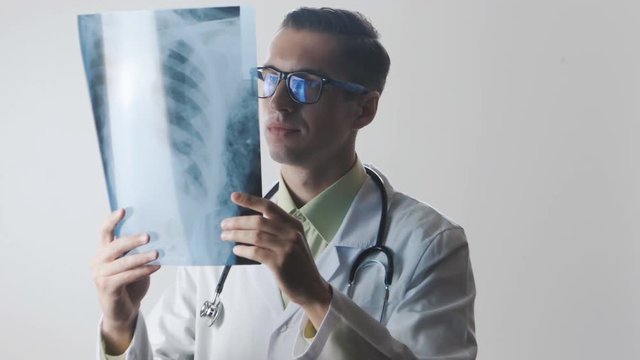 The doctor is studying an X-ray. The medical worker makes a good diagnosis