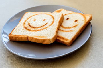 Fototapeta na wymiar Burning line as happy face on the bread sheet