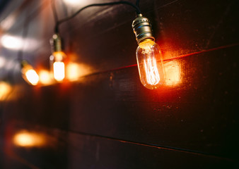 Vintage incandescent Edison type bulbs on wooden wall
