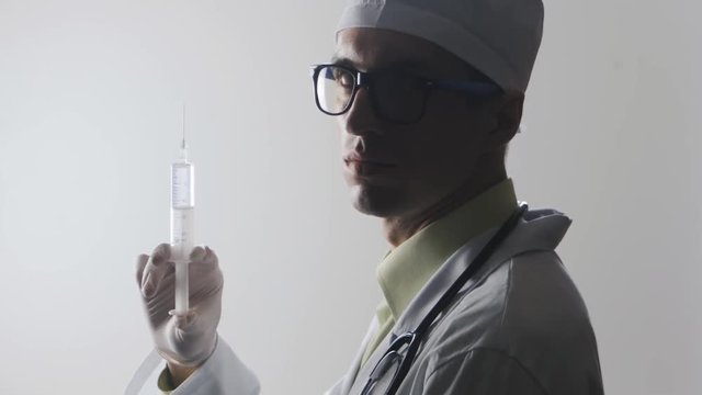Portrait of a doctor with a syringe. An injection