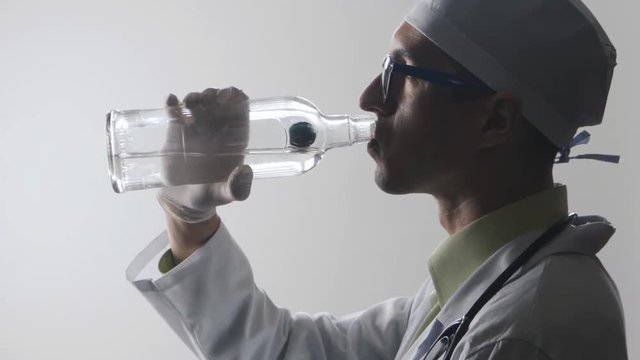 Portrait of Drunk doctor. A medical worker drinks vodka.