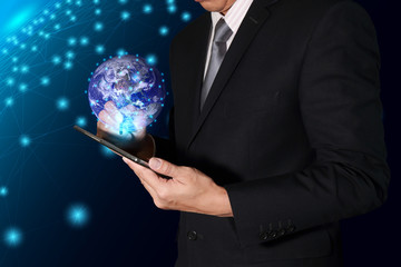 Businessman are working with tablet and light digital world on line glow network background as business, technology, innovation and globalization concept. Elements of this image furnished by NASA