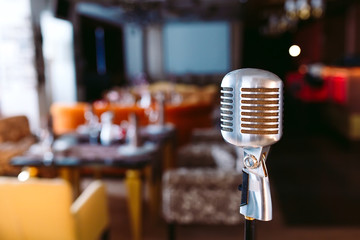 Retro karaoke microphone on restaurant background.
