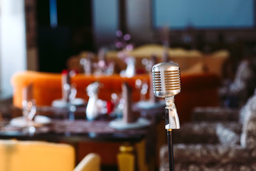 Retro karaoke microphone on restaurant background.