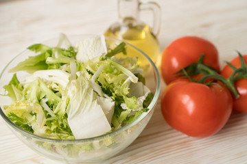 Healthy veggie salad ingridients. Tomato, lettuce and olive oil.