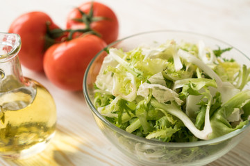 Healthy veggie salad ingridients. Tomato, lettuce and olive oil.