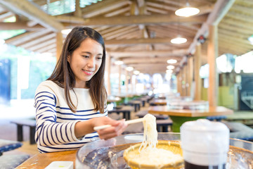 Woman eating japanese somen in restaurant