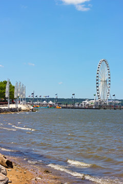 The National Harbor coastline and pier with Ferris. National Harbor waterfront on a bright sunny day, Maryland, USA.