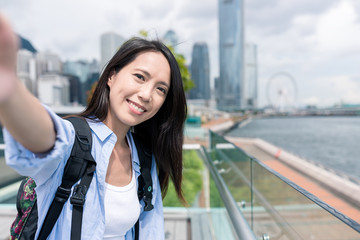 Woman holding camera to take selfie in Hong Kong