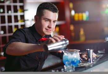 Bartender pouring fresh cocktail in fancy glass