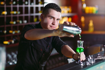 Bartender pouring fresh cocktail in fancy glass