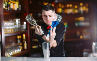 Bartender pouring fresh cocktail in fancy glass