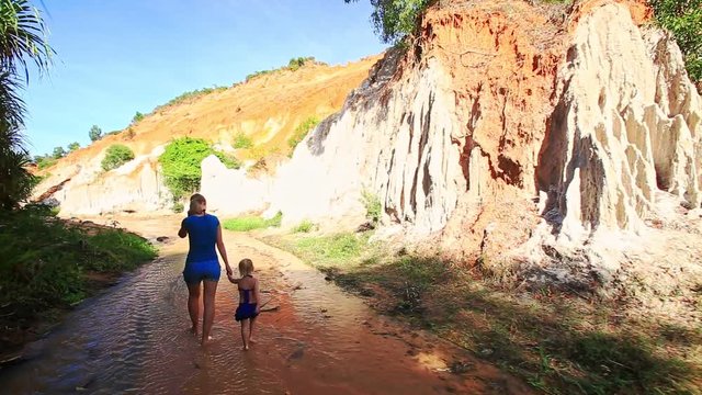 Mother Little Girl Walk along Water Stream to Steep Cliff