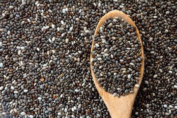 Close up chia seeds in wooden spoon on chia seeds background