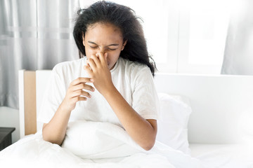 the american cute girl sick and sneeze on white bed