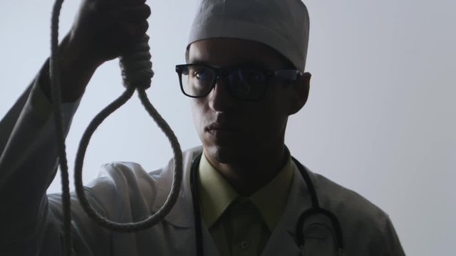 The doctor offers a choice between a noose and an injection. The choice between suicide or treatment.