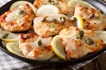 Delicious chicken piccata with sauce and lemon on plate