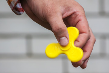 Rotating yellow spinner in the male hand