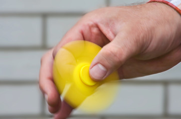 Rotating yellow spinner in the male hand