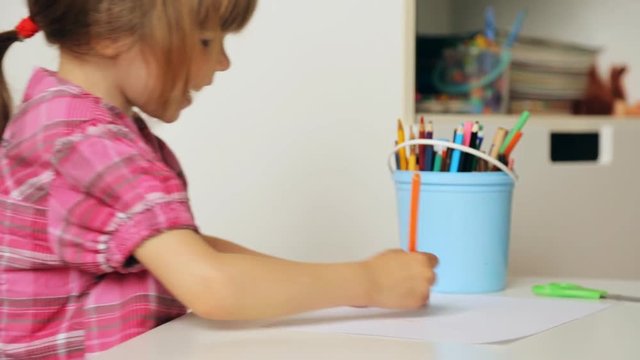 Small girl drawing with colourful pencils