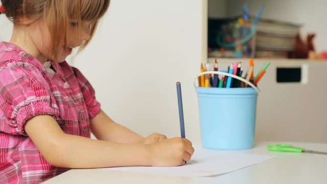 Small girl drawing with colourful pencils