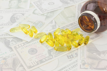 Double exposure of soft gelatin dietary supplement oil capsule and moneys  background.