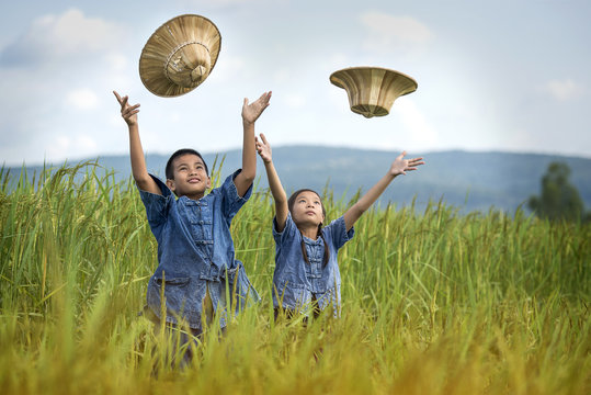 Asian children farmer on green rice field.