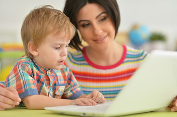 Mother and son using modern laptop