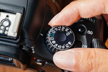 Auto dial mode on dslr camera with fingers on the dial