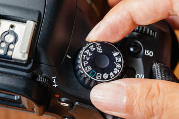 Tv dial mode on dslr camera with fingers on the dial