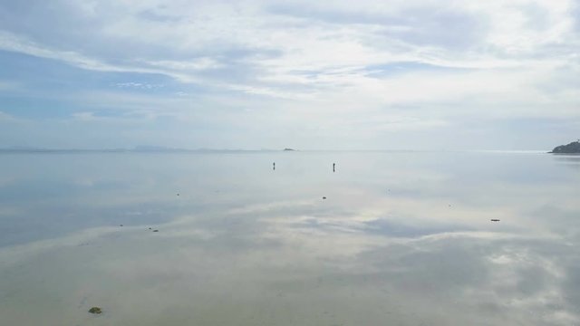 People Gathering Sea Shells at Shallow Water with Reflecting Surface. Aerial View