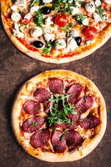 Hot pizza slice with salami, olives and cheese on a rustic wooden table. Top view. Fresh Pizza on dark background  with Copy space.