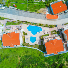 Top view of red tiled roofs of the houses and the swimming pool