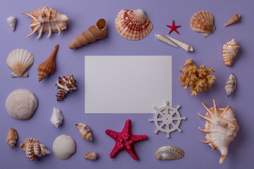 Summer composition: From above view of paper card mockup surrounded with seashells and sea stars on purple background. Top view. Flat lay.